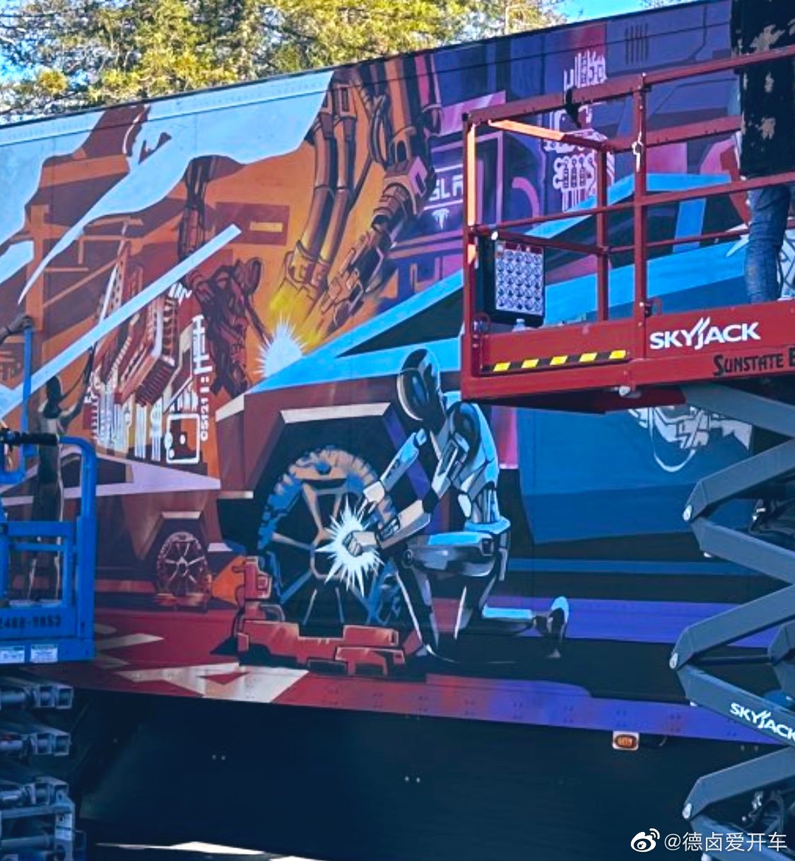 一些 AI Day 2022 活动现场照片， semi 集装箱涂鸦画着一个机器人正在修车。

#特斯拉#

  - 图片 9